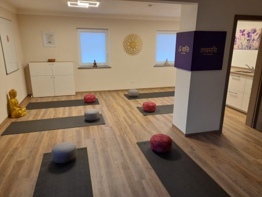 Bewusstseinsabend Meditationsraum mit Yogamatten, Kissen und sanfter Beleuchtung, ruhige Atmosphäre.