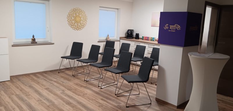 Seminarraum Seminarraum mit schwarzen Stühlen, Stehtisch und dekorativen Elementen in hellem Raum.